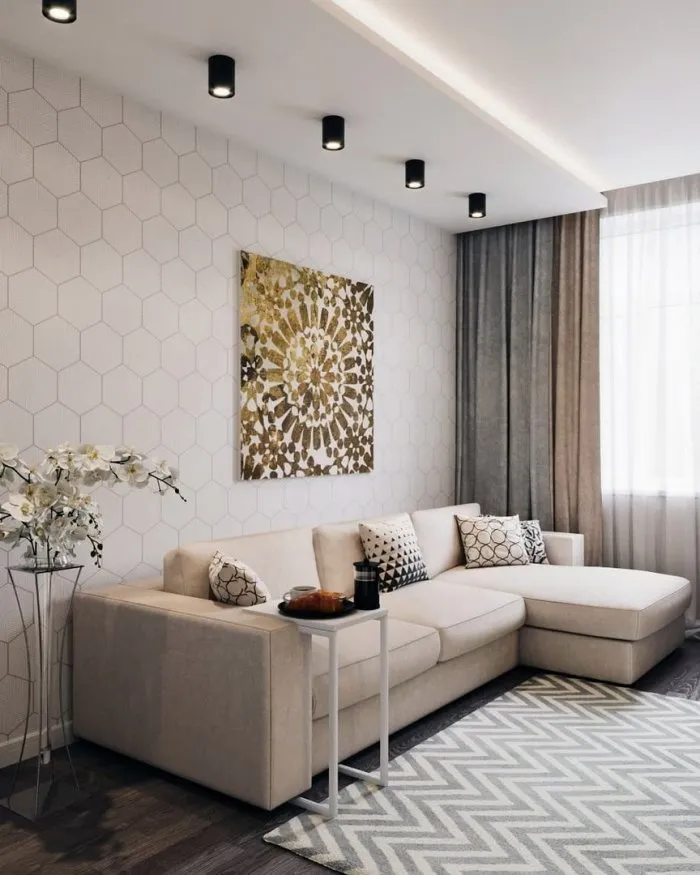 Интерьер гостиной с угловым диваном и ковром в светлых тонах