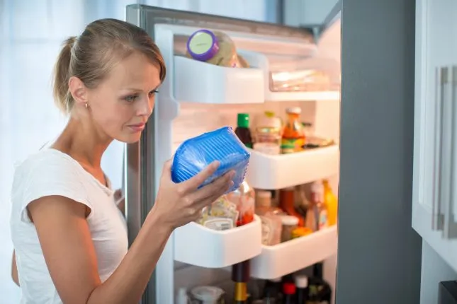 Девушка, холодильник, контейнер с продуктами